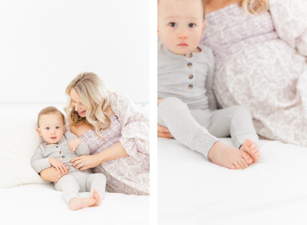 A mother cuddling with her baby on an all white bed