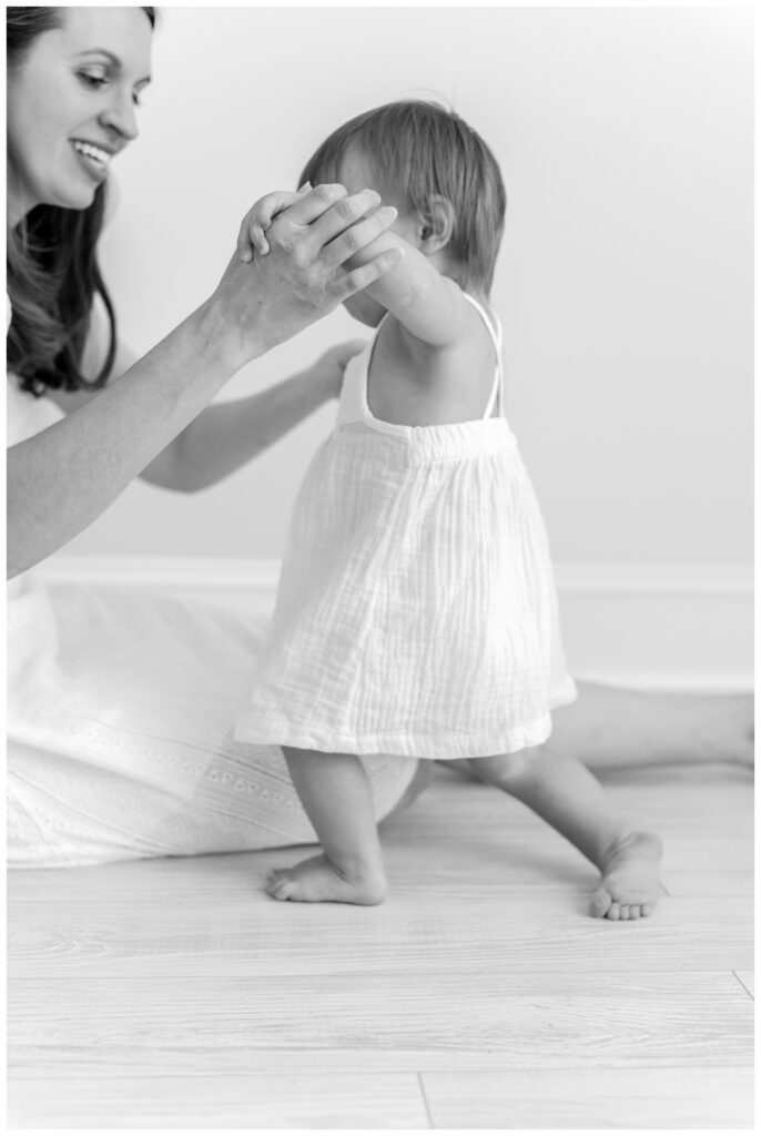 A mother helping her baby walk by DC Baby Photographer