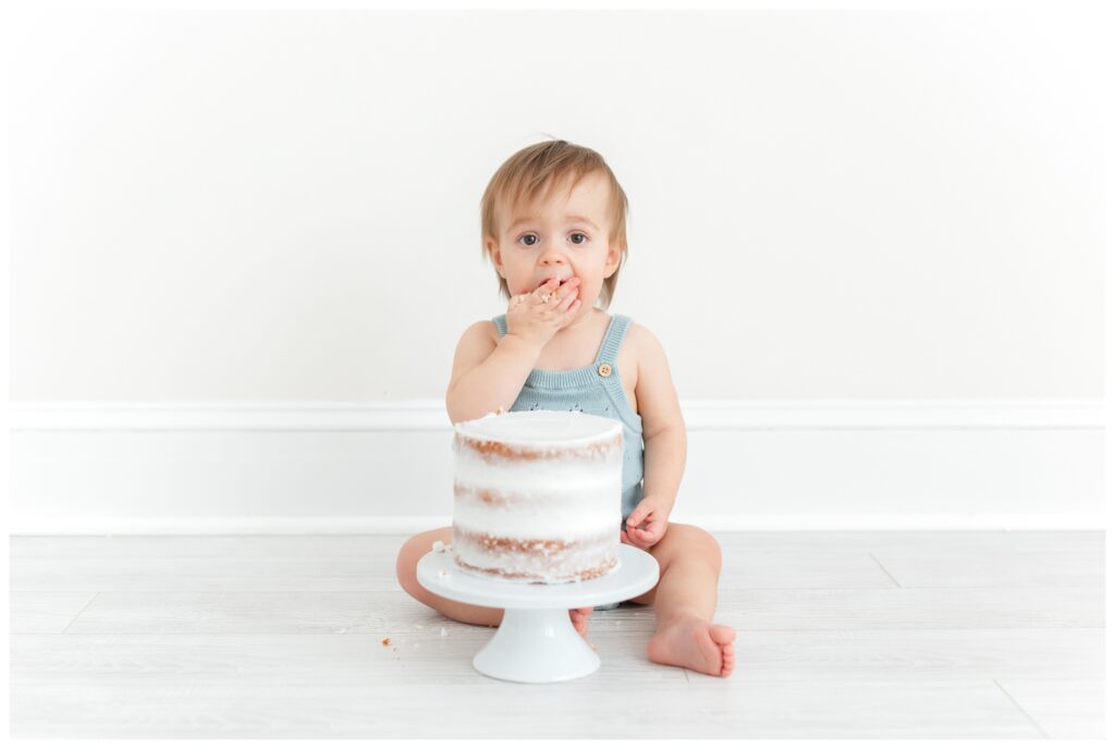 A baby smashing cake in her face by DC Baby Photographer