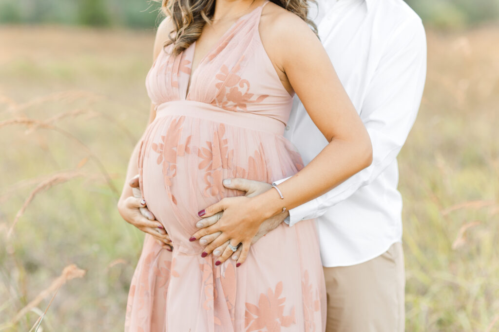 A closeup photo of a baby bump at their maternity session as one of their date night ideas DC