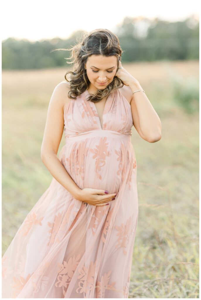 A pregnant mother holding her belly and looking down lovingly at her baby bump while taking Northern Virginia Maternity Photographer