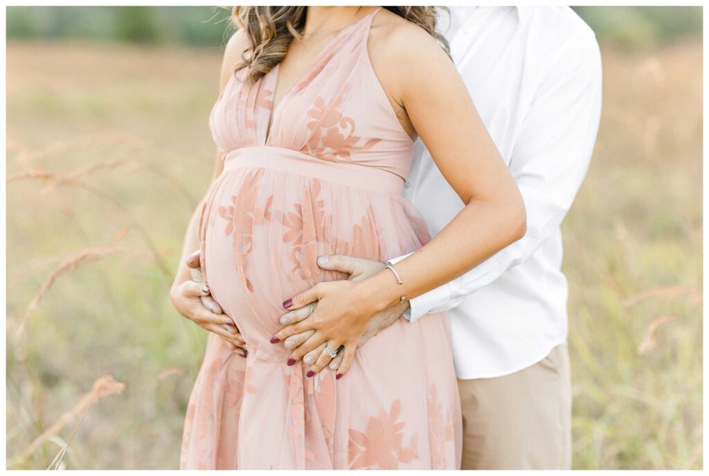 A closeup photo of an expecting mother's belly being held by her husband while taking their maternity photos in DC
